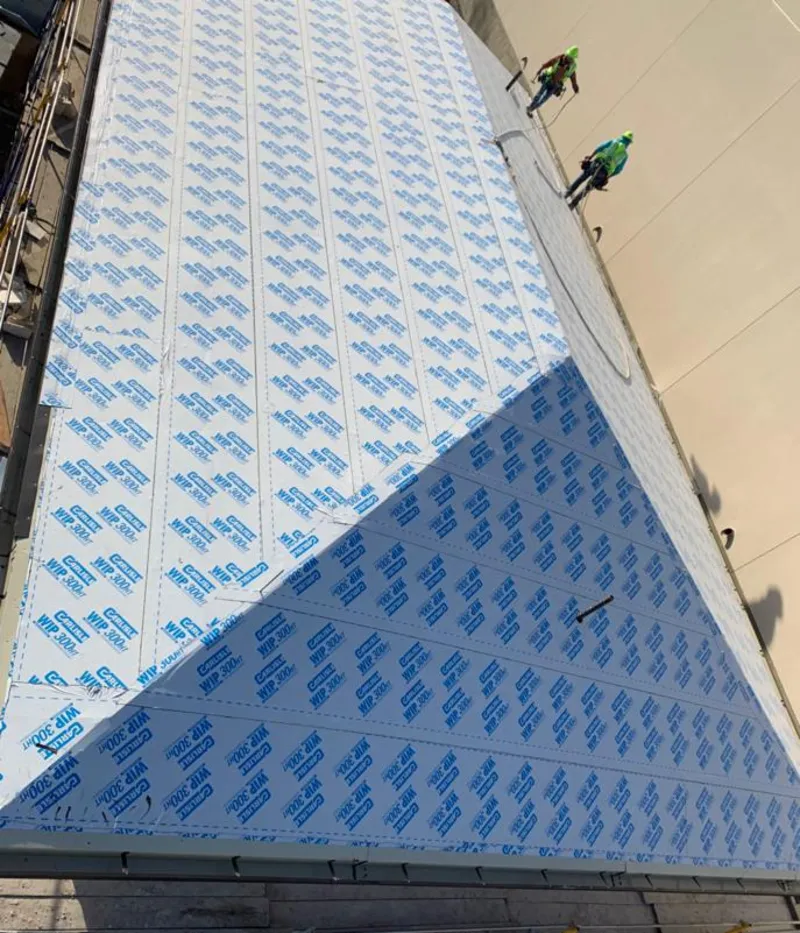 Professional roofers installing underlayment on a metal roof in Thermalito